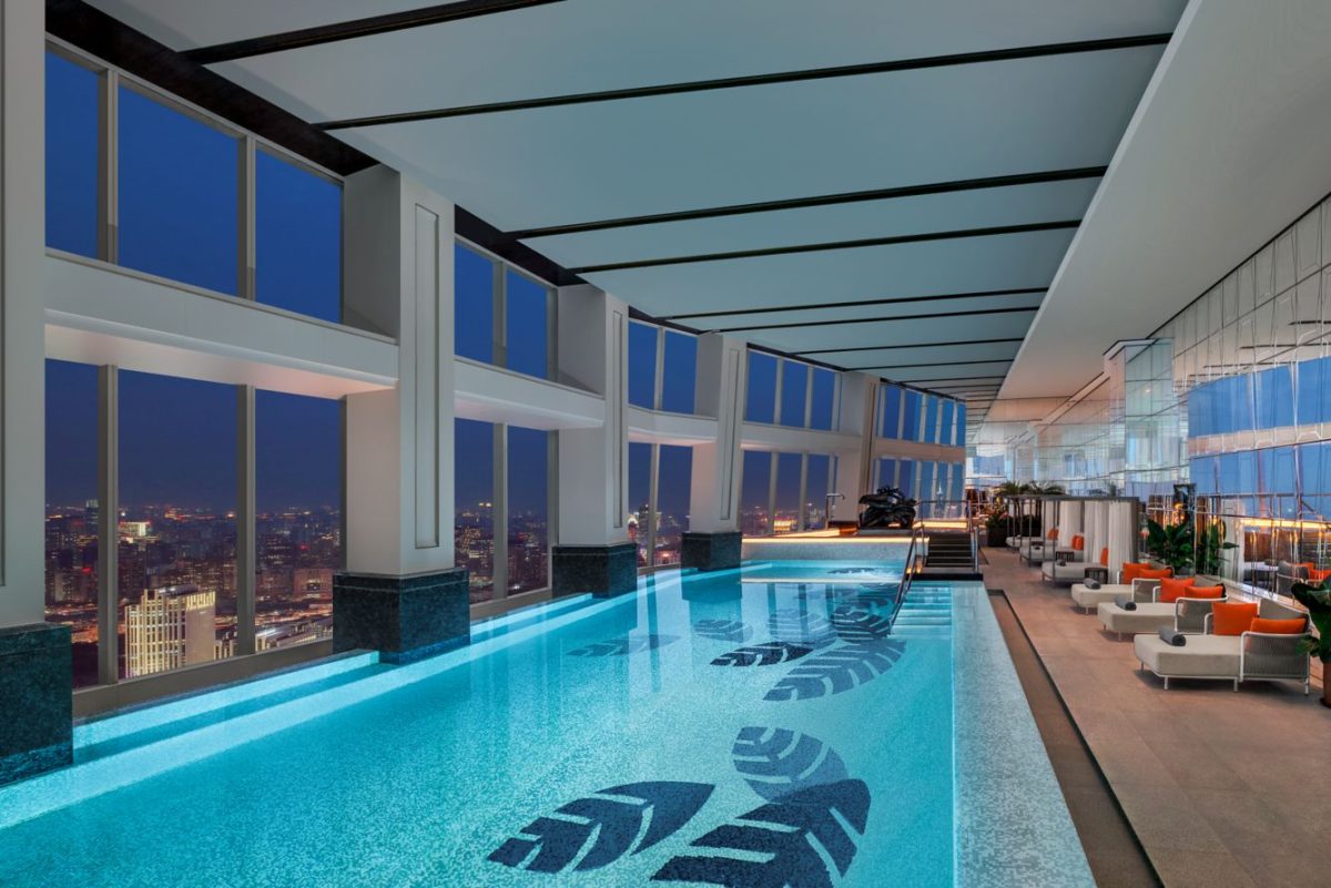 Luxurious indoor swimming pool on a high floor with panoramic city views through floor-to-ceiling windows
