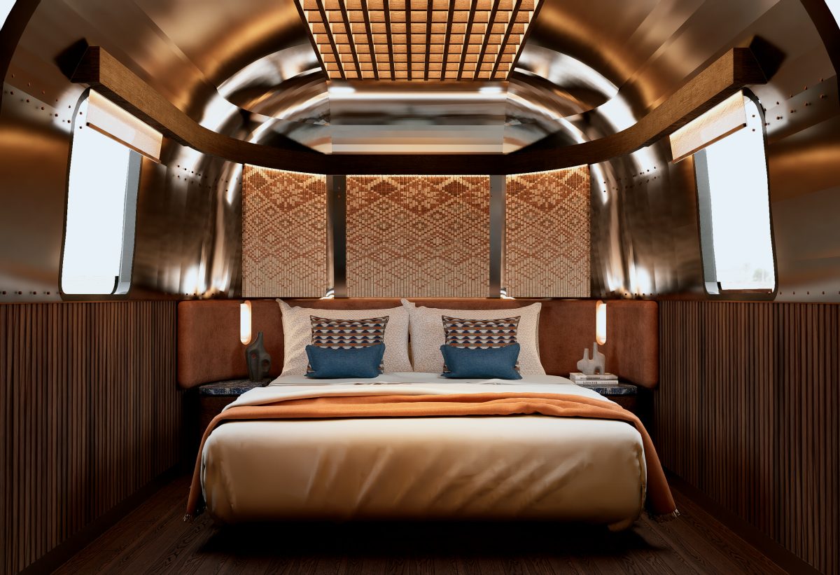 Luxurious interior of an Airstream trailer, showcasing a comfortable bed and stylish decor.
