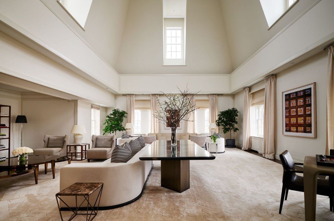 Luxurious penthouse suite with high ceilings, modern furnishings, and skyline views