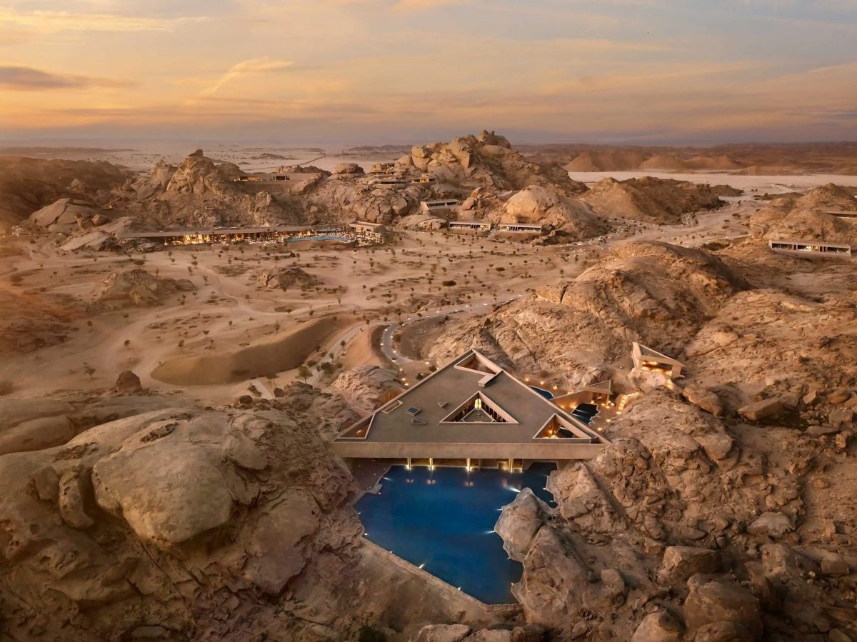 Luxury resort nestled among rocky desert landscape with blue pool overlooking Red Sea