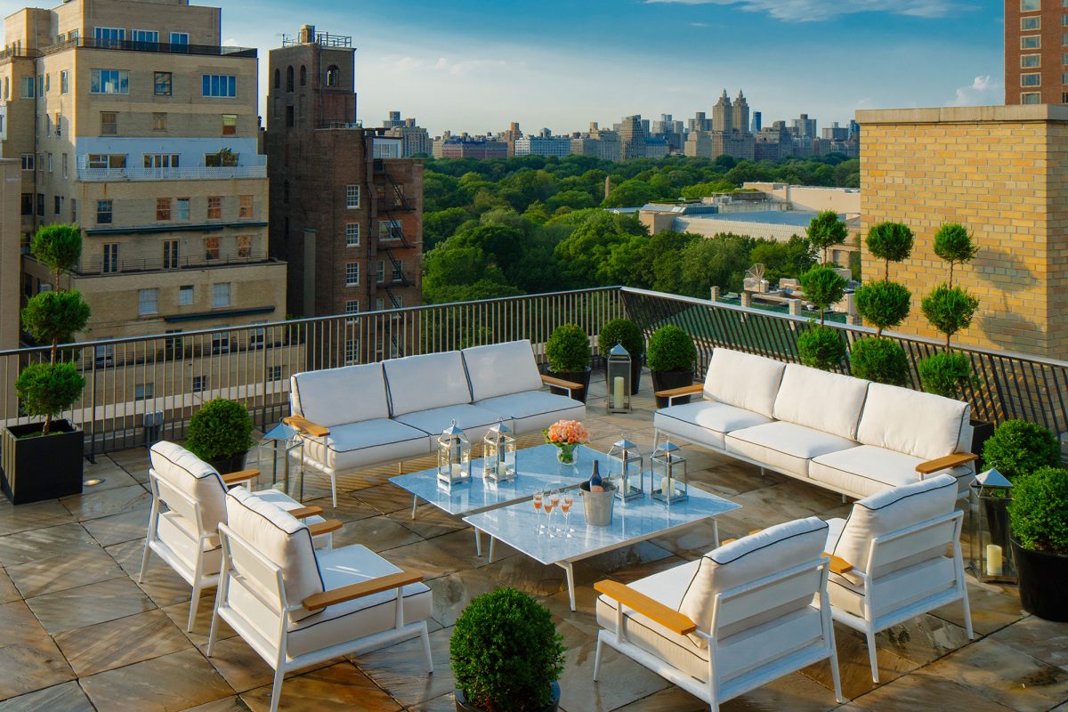 Luxury rooftop terrace with white furniture overlooking Manhattan skyline