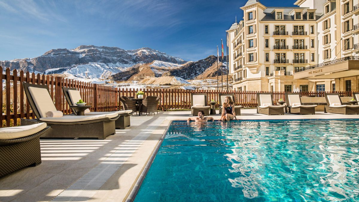 Luxury spa resort with heated pool overlooking snow-capped mountains