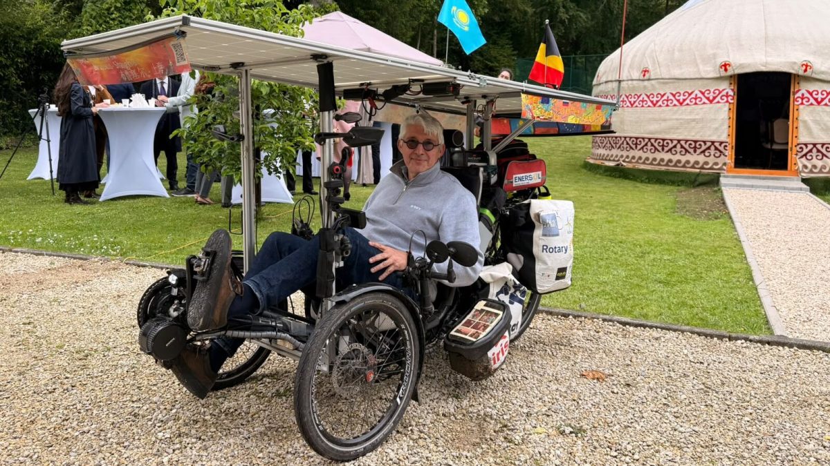 Man riding a recumbent trike at an outdoor festival in Kazakhstan