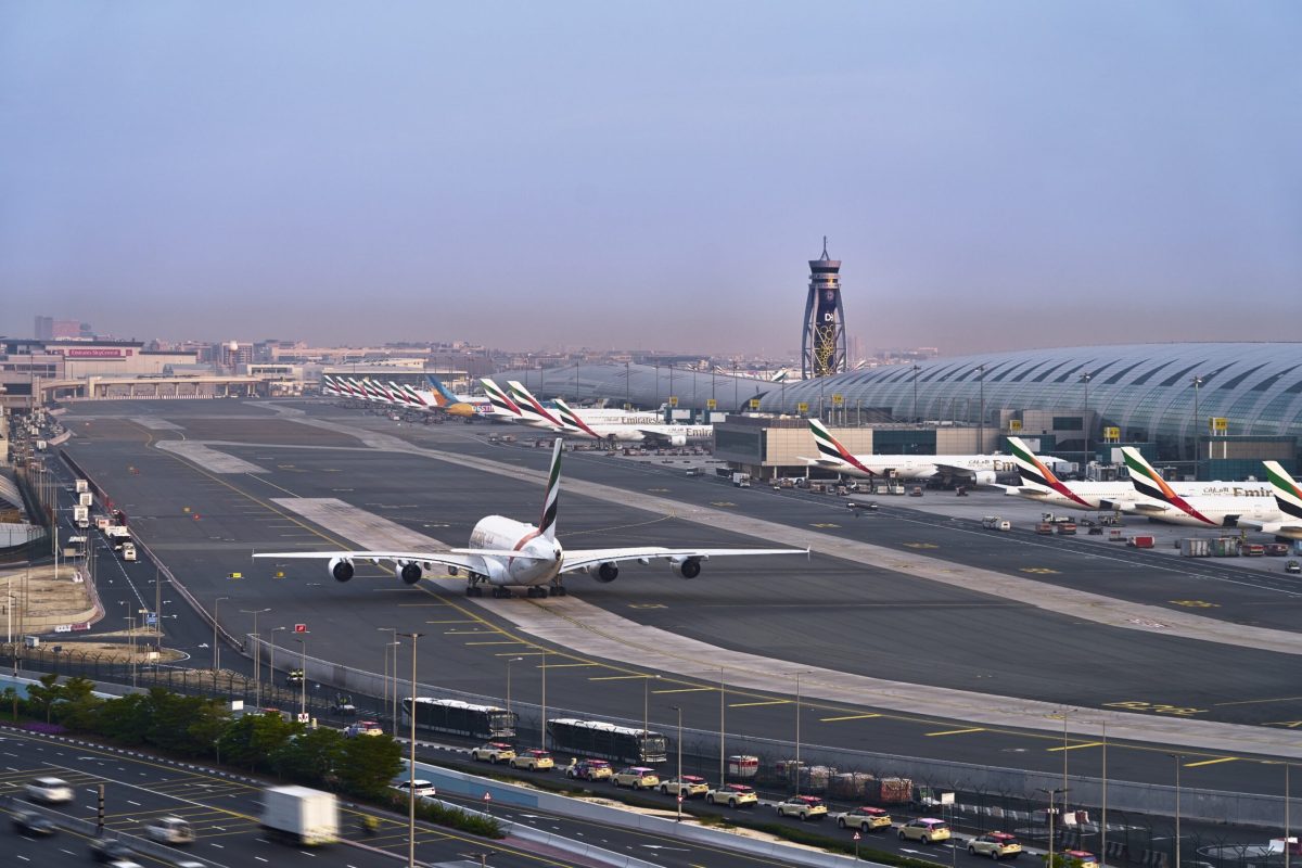 Aerial view of Dubai International Airport runway with aircraft and terminal buildings