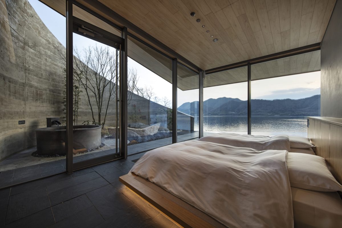 Modern bedroom with expansive windows overlooking Seto Inland Sea and mountains