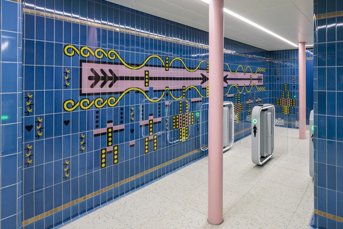 Modern blue-tiled restroom at Piccadilly Circus tube station with decorative yellow and pink artistic wall designs