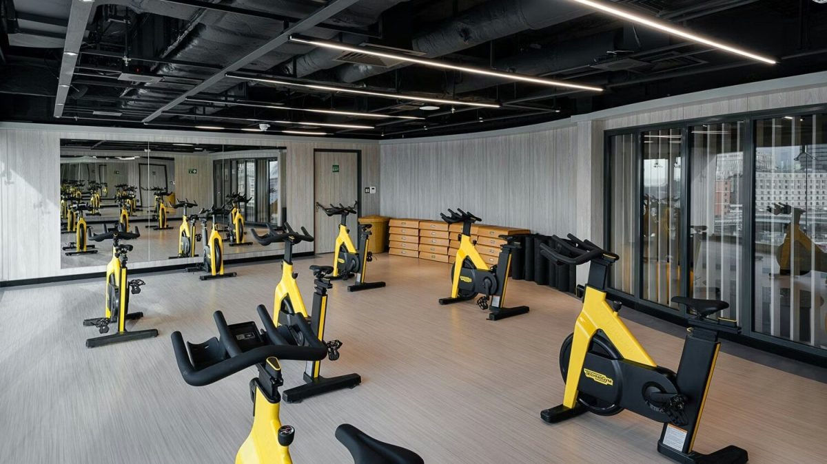 Modern fitness studio with yellow stationary bikes and exercise equipment