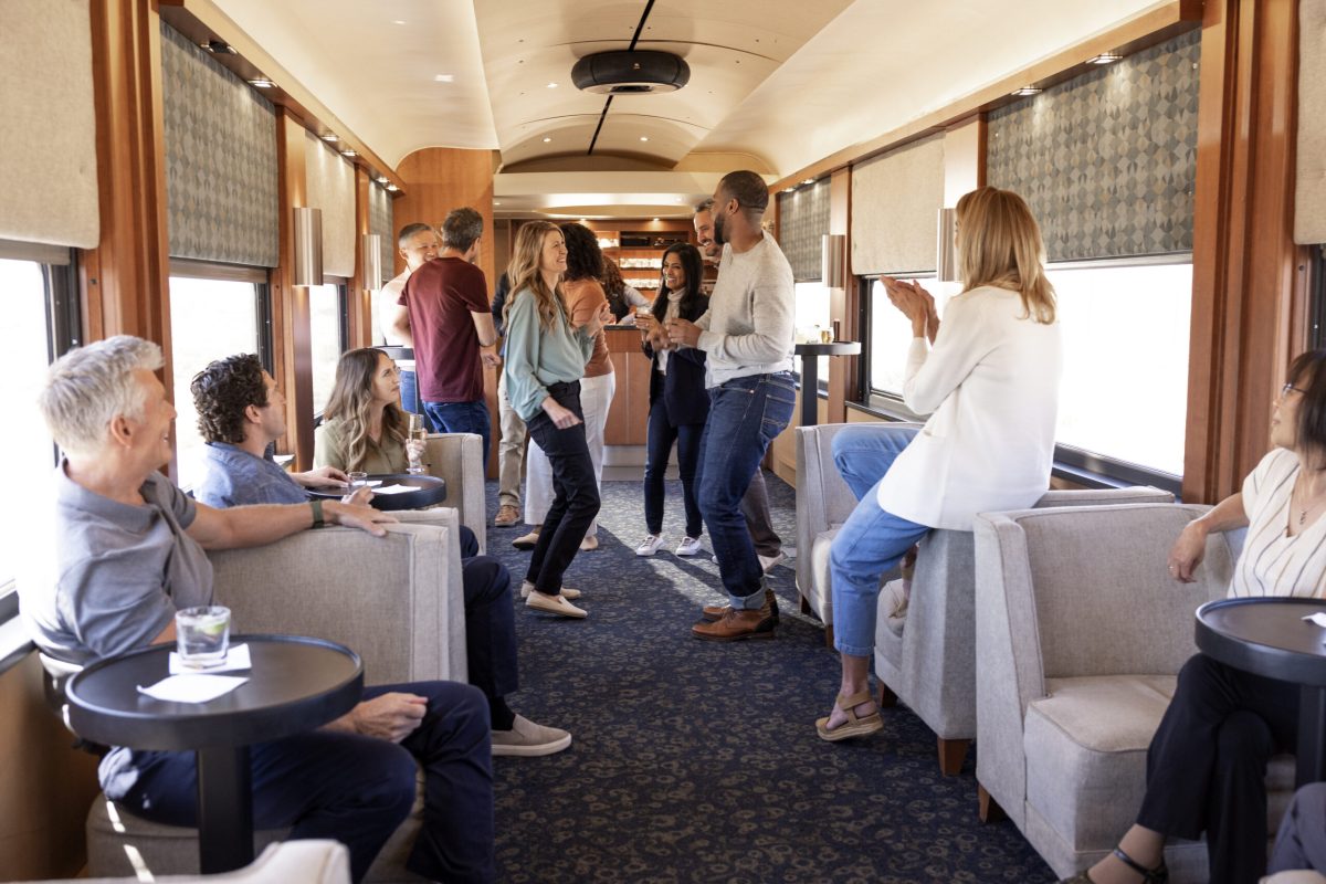 Modern train car interior with passengers socializing and enjoying the journey.