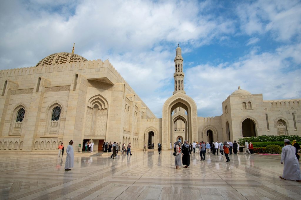 Courtyard of Al-Hakim Mosque in Muscat with visitors in traditional dress