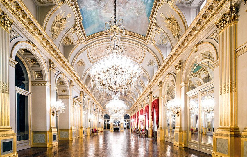 Ornate golden hall with crystal chandelier and decorated ceiling in Brussels Royal Palace