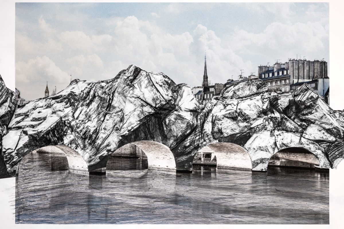 Monumental rocky structure spanning across a Paris river with classical architecture visible behind