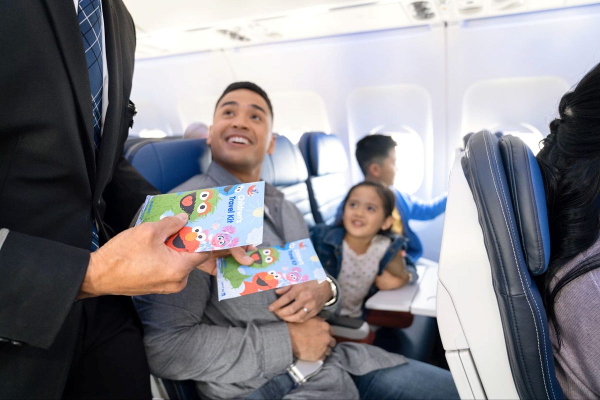 Passenger holding currency while seated on aircraft with flight attendant nearby