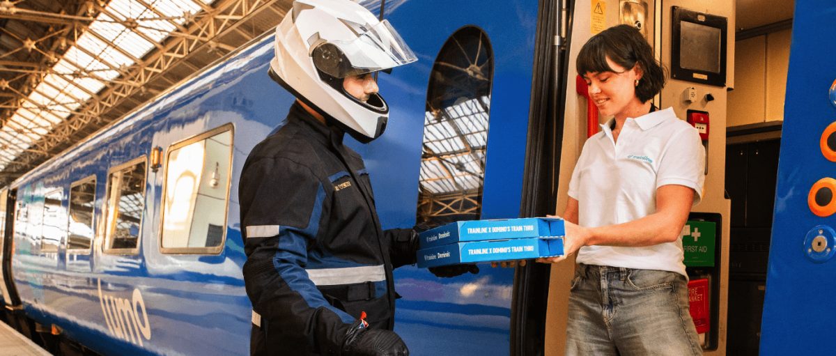 Passenger receiving Domino's pizza delivery directly at train seat window