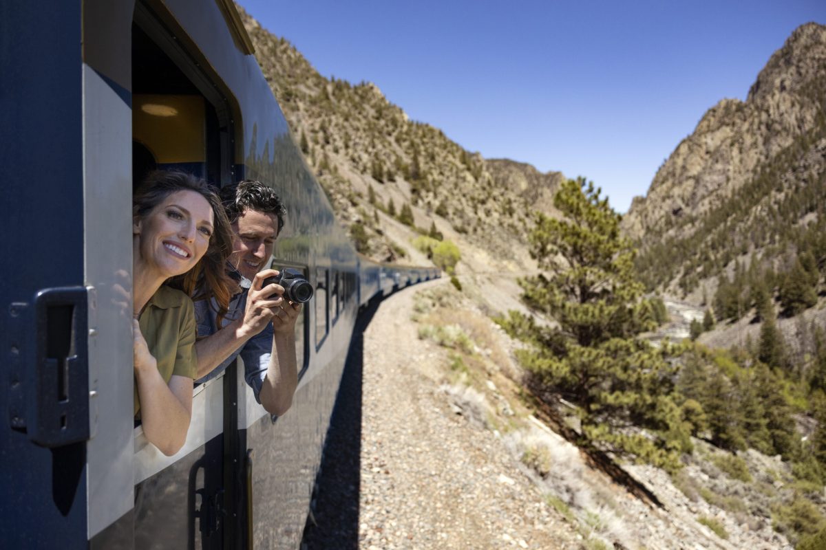 Passengers enjoying scenic views from a train window, capturing the landscape.