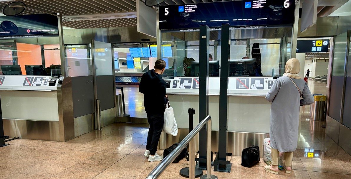 Passengers queue at border control booths in Brussels Airport.