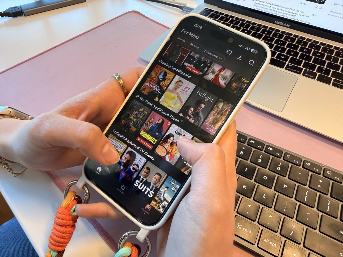 Person holding smartphone displaying Netflix's vertical video feed interface with content thumbnails