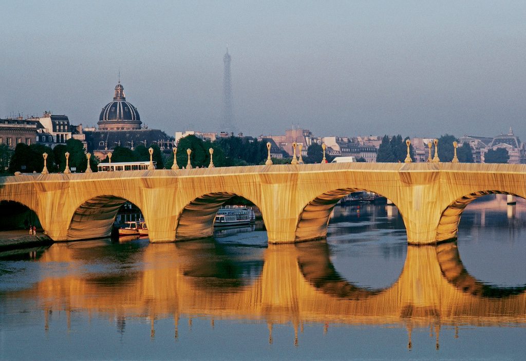 Pont Neuf bridge in Paris reflecting in the Seine river at golden hour