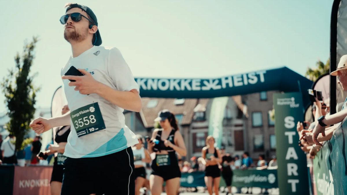 Runner at Knokke-Heist spring event with coastal architecture and spectators