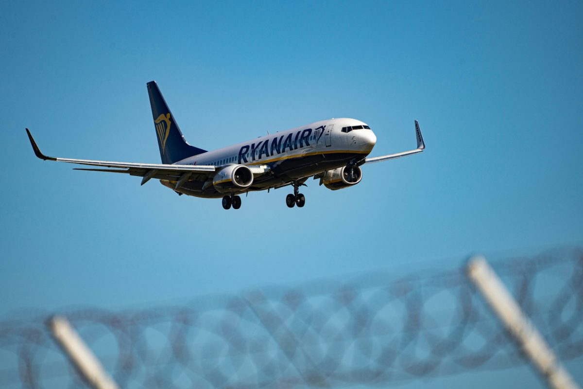 Ryanair Boeing 737 takes off against a bright blue sky.