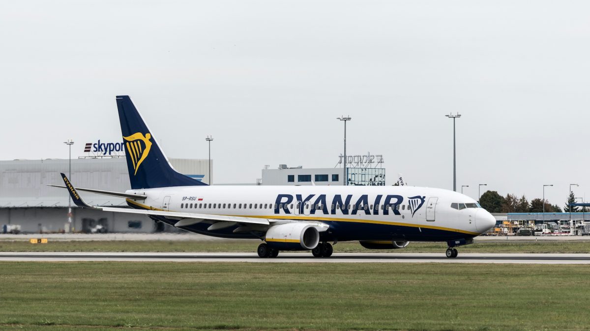 Ryanair Boeing 737 aircraft parked at airport gate with ground infrastructure visible