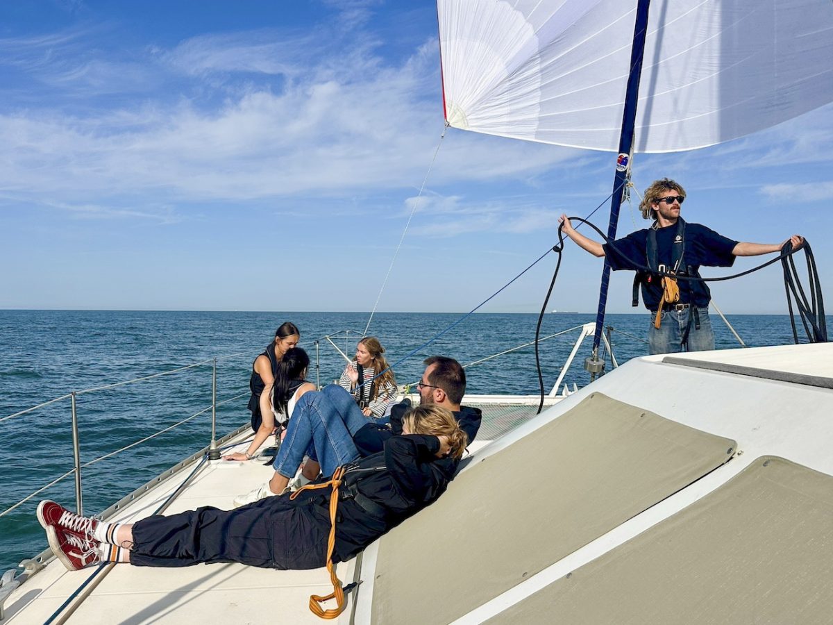 Sailors on a white sailboat with billowing sail crossing the English Channel