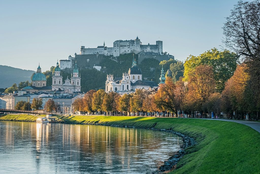 Salzburg's historic old town with Hohensalzburg Fortress overlooking the Salzach River and autumn trees