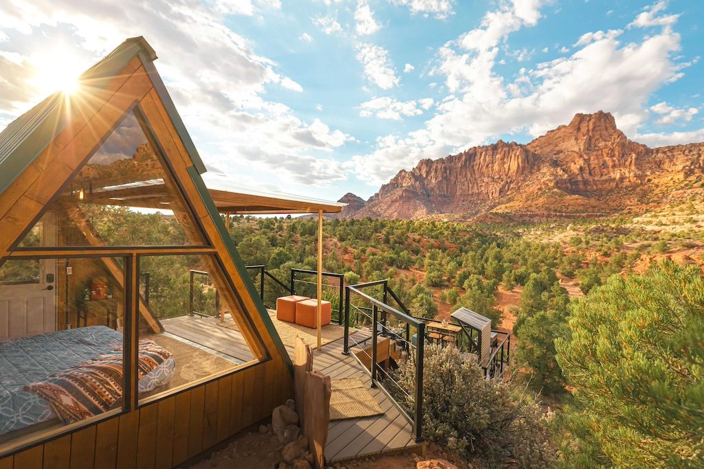 Modern geometric cabin with glass panels overlooking red rock desert landscape