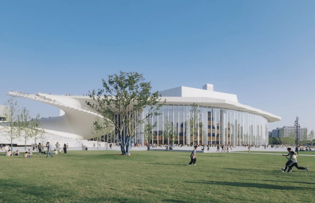Shanghai Opera House's white, curved roof and glass facade against a blue sky.
