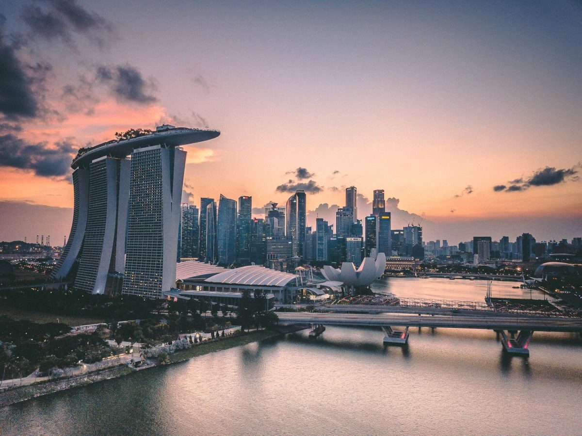 Singapore skyline at sunset with Marina Bay Sands and illuminated buildings reflected in water