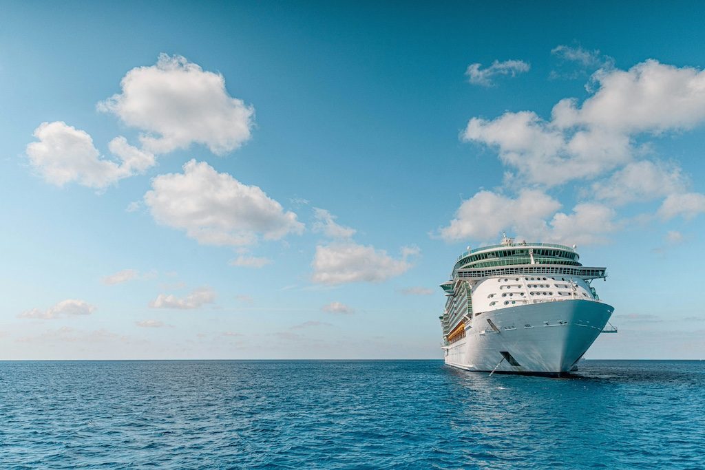 Large cruise ship anchored in turquoise ocean waters under blue sky