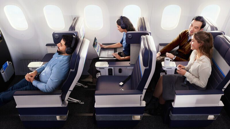 Passengers sitting in airline seats with windows visible in the background