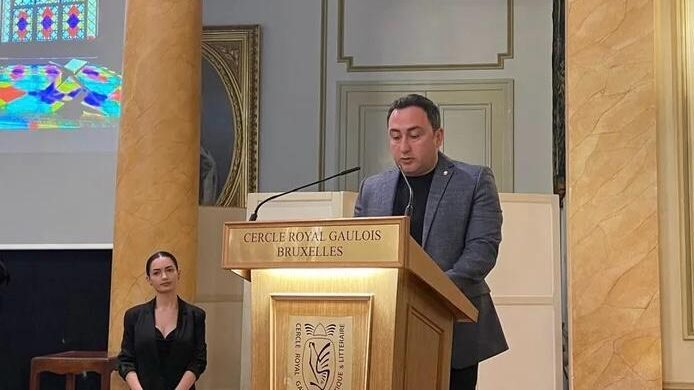 Speaker at podium during Azerbaijan cultural heritage exhibition opening in Brussels