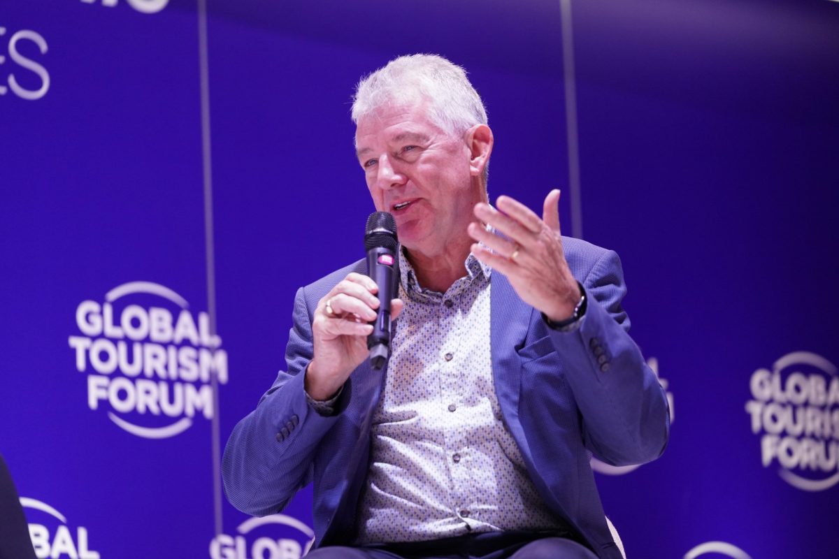 Speaker gesturing while addressing audience at Global Tourism Forum event