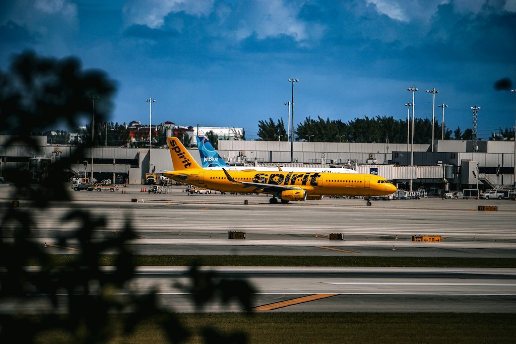 Yellow DHL cargo plane parked at airport terminal with blue sky overhead