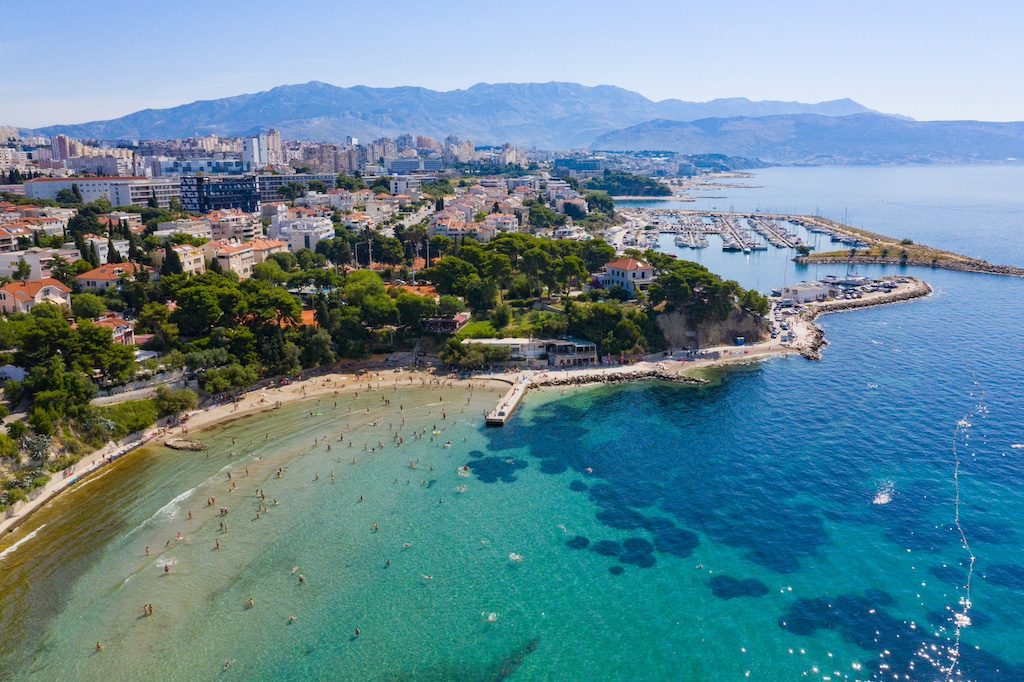Aerial view of Split's turquoise coastline and beachfront city nestled against mountains