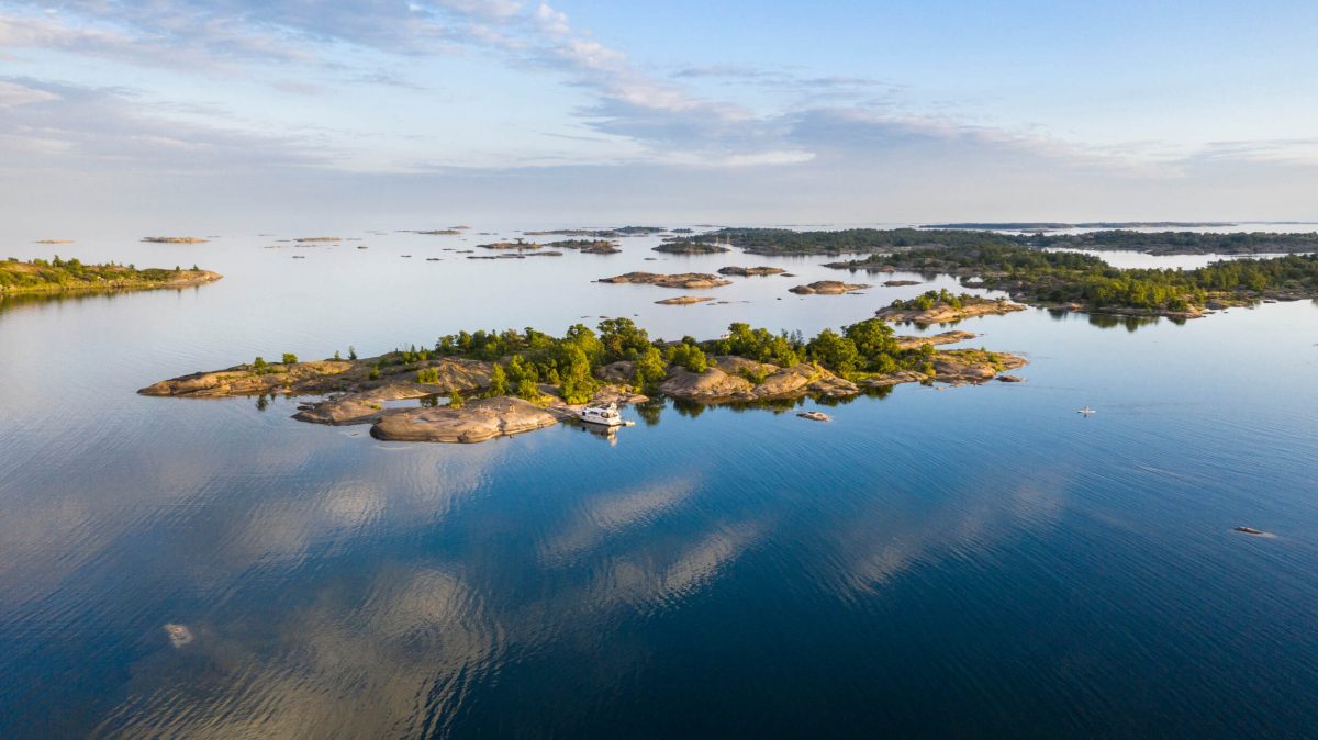 Aerial view of forested islands dotting calm blue waters in Sweden's archipelago