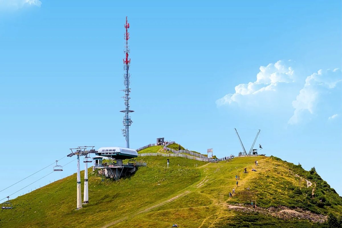 Mountain peak with transmission tower and summer adventure equipment installations in Swiss Alps