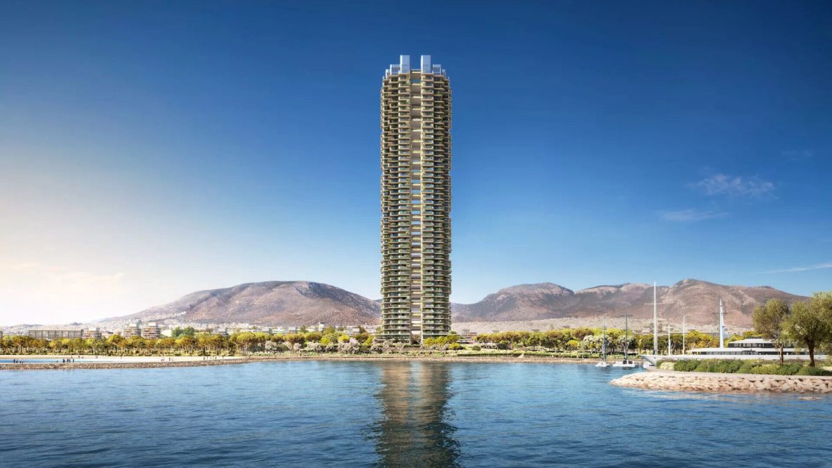 Tall residential tower rising from waterfront with mountains in background