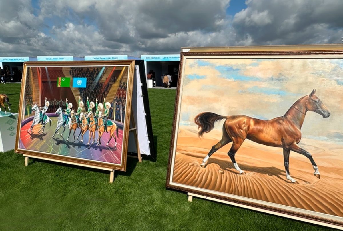 Large framed paintings of horses displayed outdoors at an equestrian event