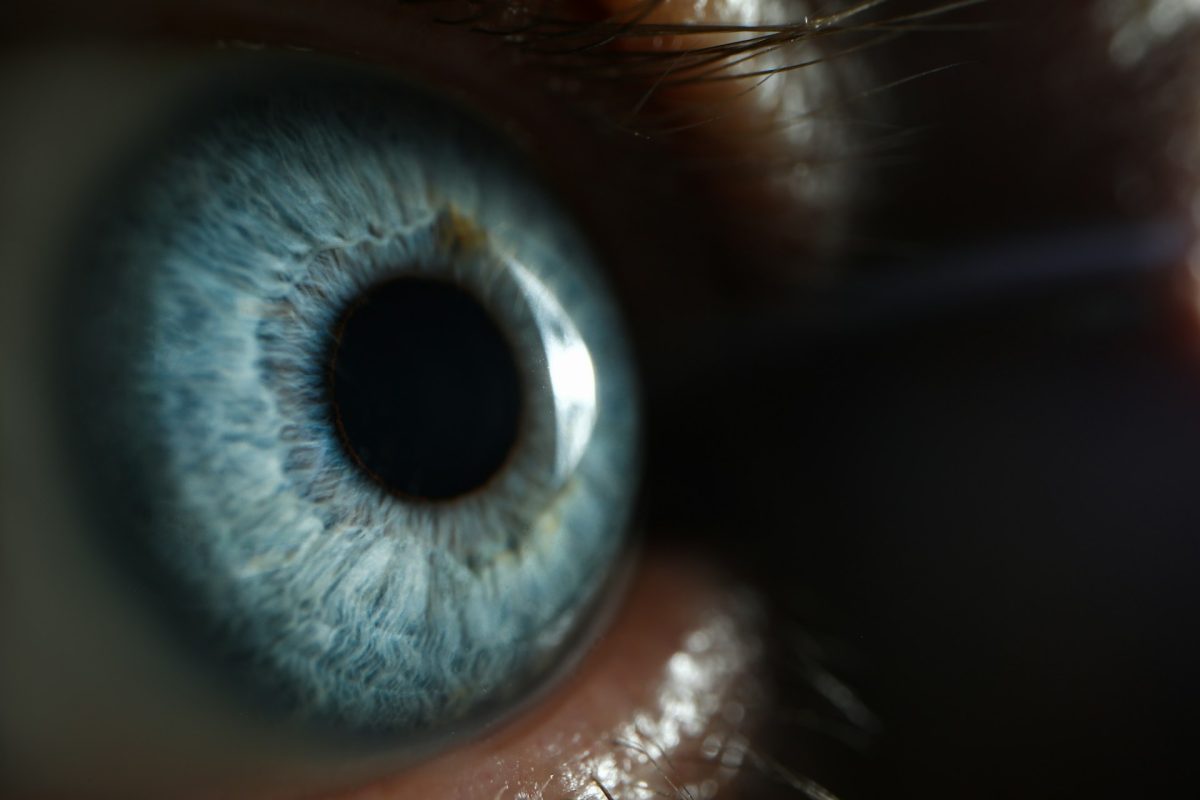 Close-up of a striking blue eye with intricate iris patterns against darker skin