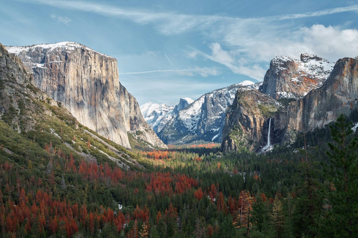 Yosemite Valley with El Capitan and waterfalls surrounded by evergreen forests and autumn foliage
