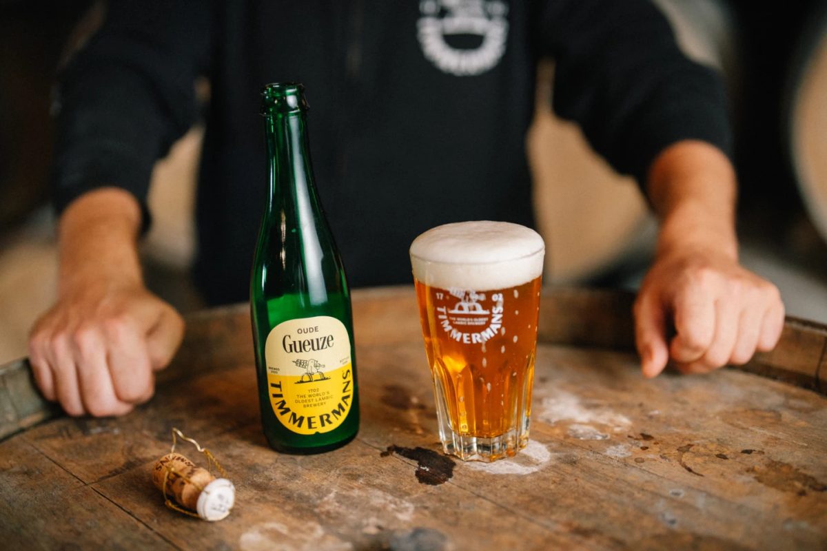 Timmermans lambic beer in a bottle and glass, with corks nearby.