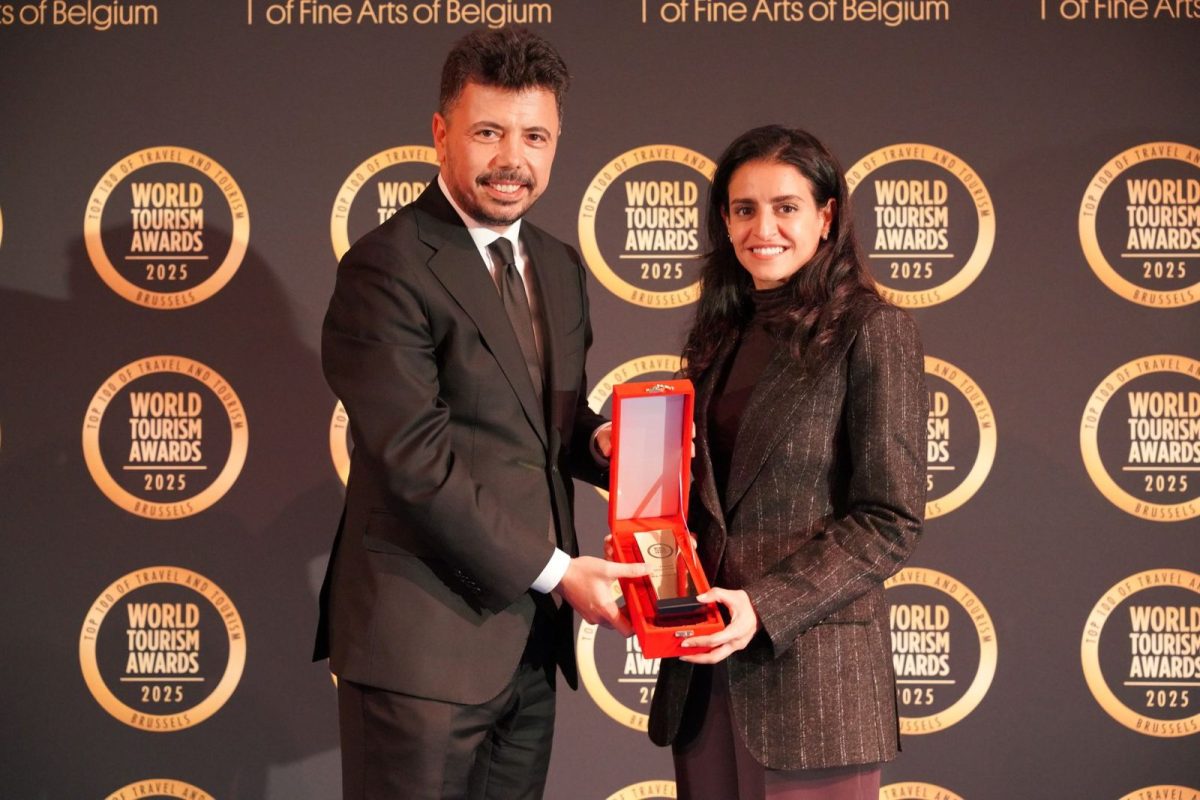 Two professionals holding a red award trophy at the World Tourism Awards ceremony