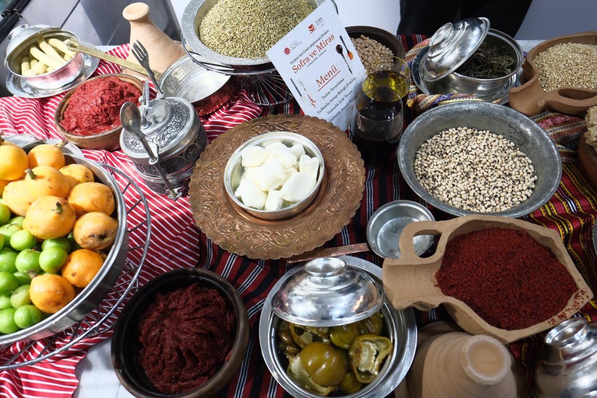 Traditional Gaziantep ingredients including spices, nuts, grains, vegetables and olives arranged on a table