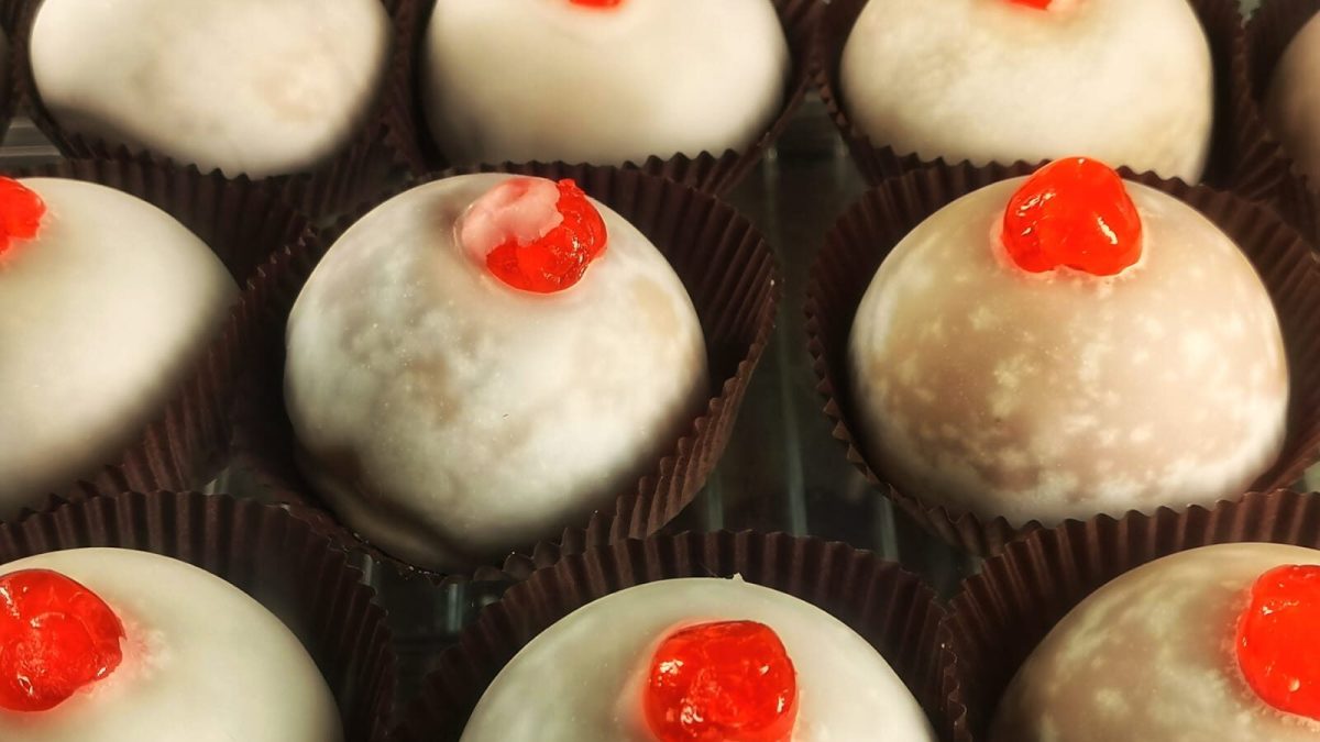 Traditional Italian pastries with white icing and red cherry garnish