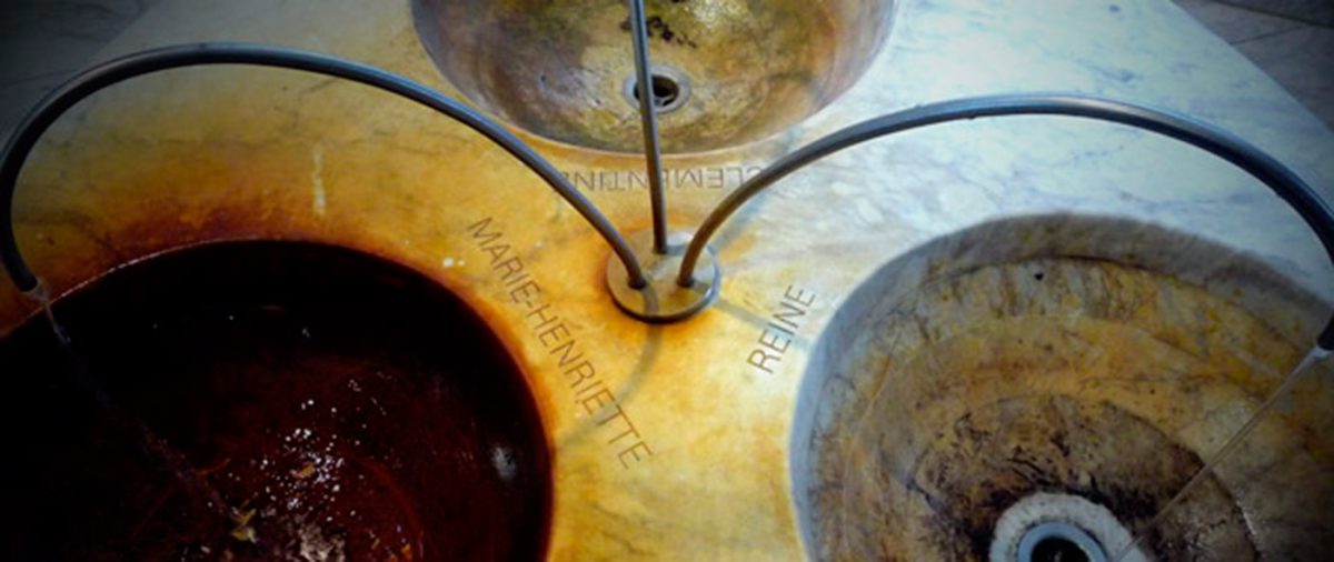 Traditional spa water basins showing mineral-rich waters in different colors