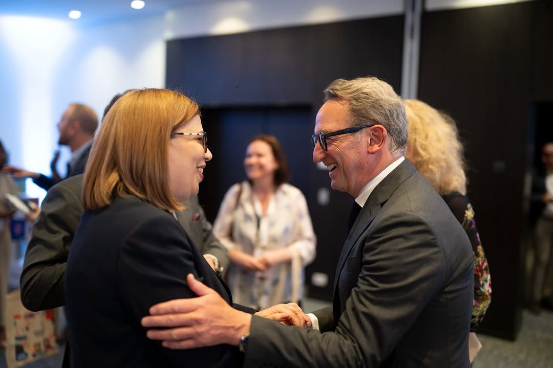Two business professionals greeting each other at a Dominican Republic economic forum in Brussels
