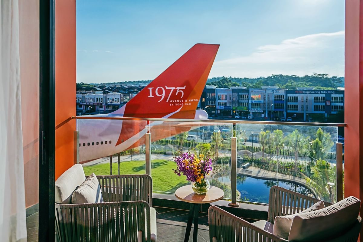 Balcony view of red Boeing 747 tail with 1975 marking overlooking green landscape