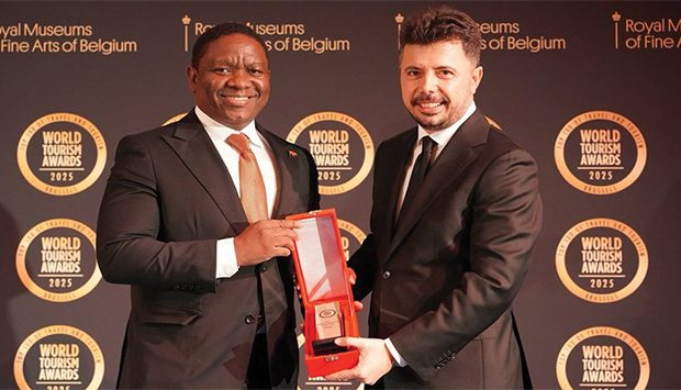 Two men in suits holding a red award at Global Tourism Forum event