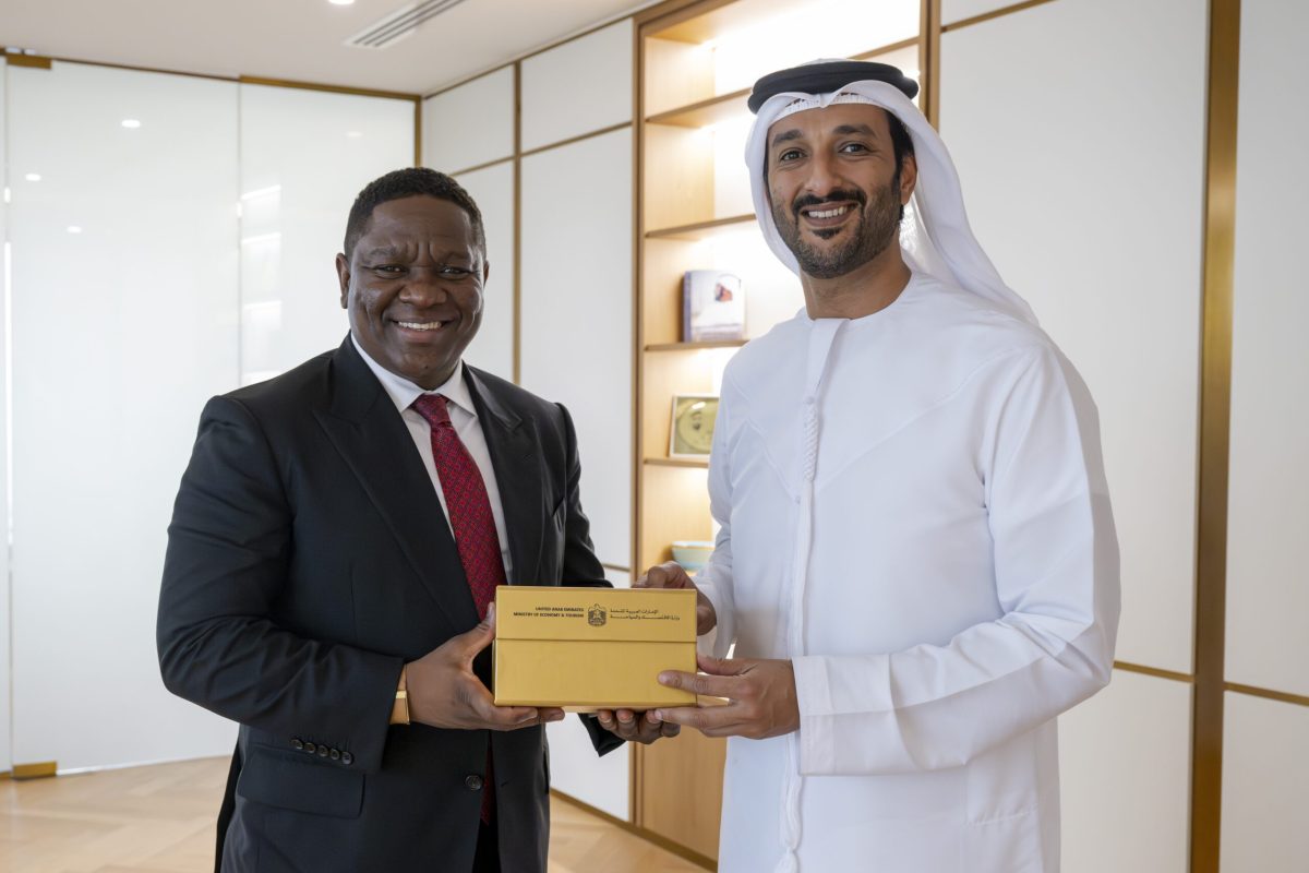 Two officials exchanging a golden award during a bilateral meeting